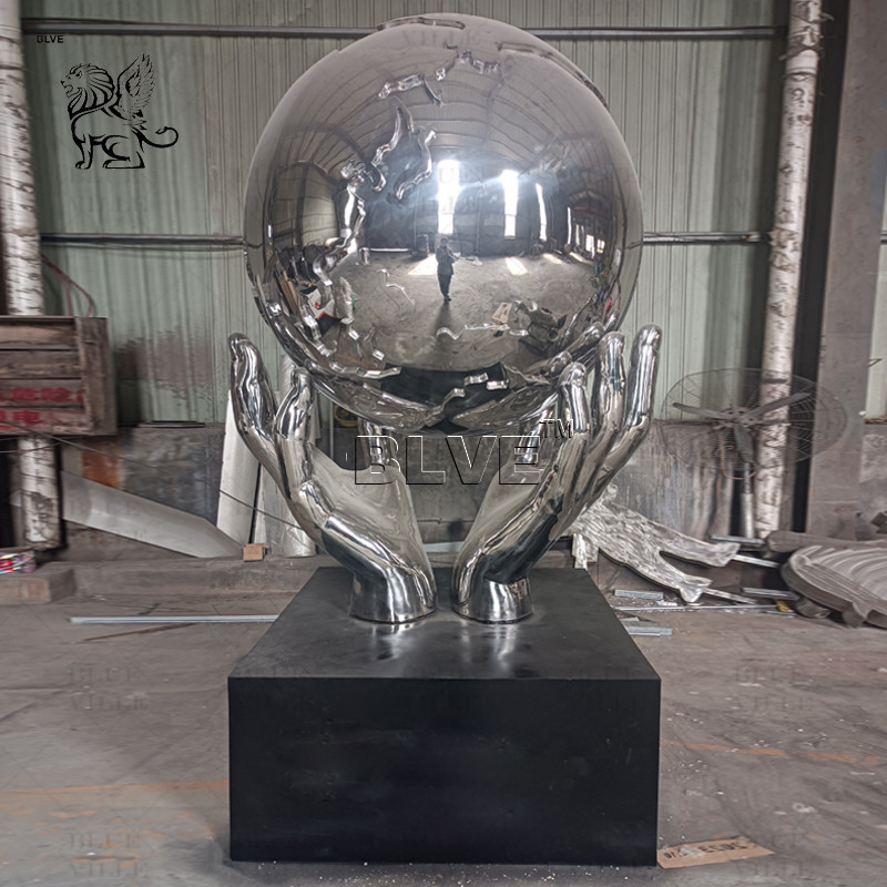 China Stainless Steel Holding Earth Sculpture Large Mirror Polished Metal World Globe Statues Decoration Outdoor Square Custom factory