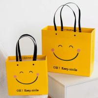 Quality ISO Shock Resistant Smile Face Kraft Paper Bags Yellow Square Bottom Paper Bag for sale
